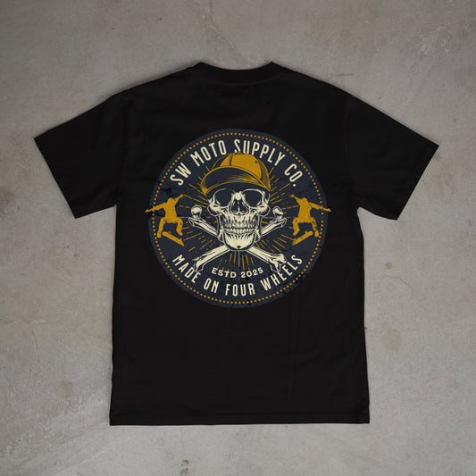 Black t-shirt with a skull and crossbones design on a gray surface
