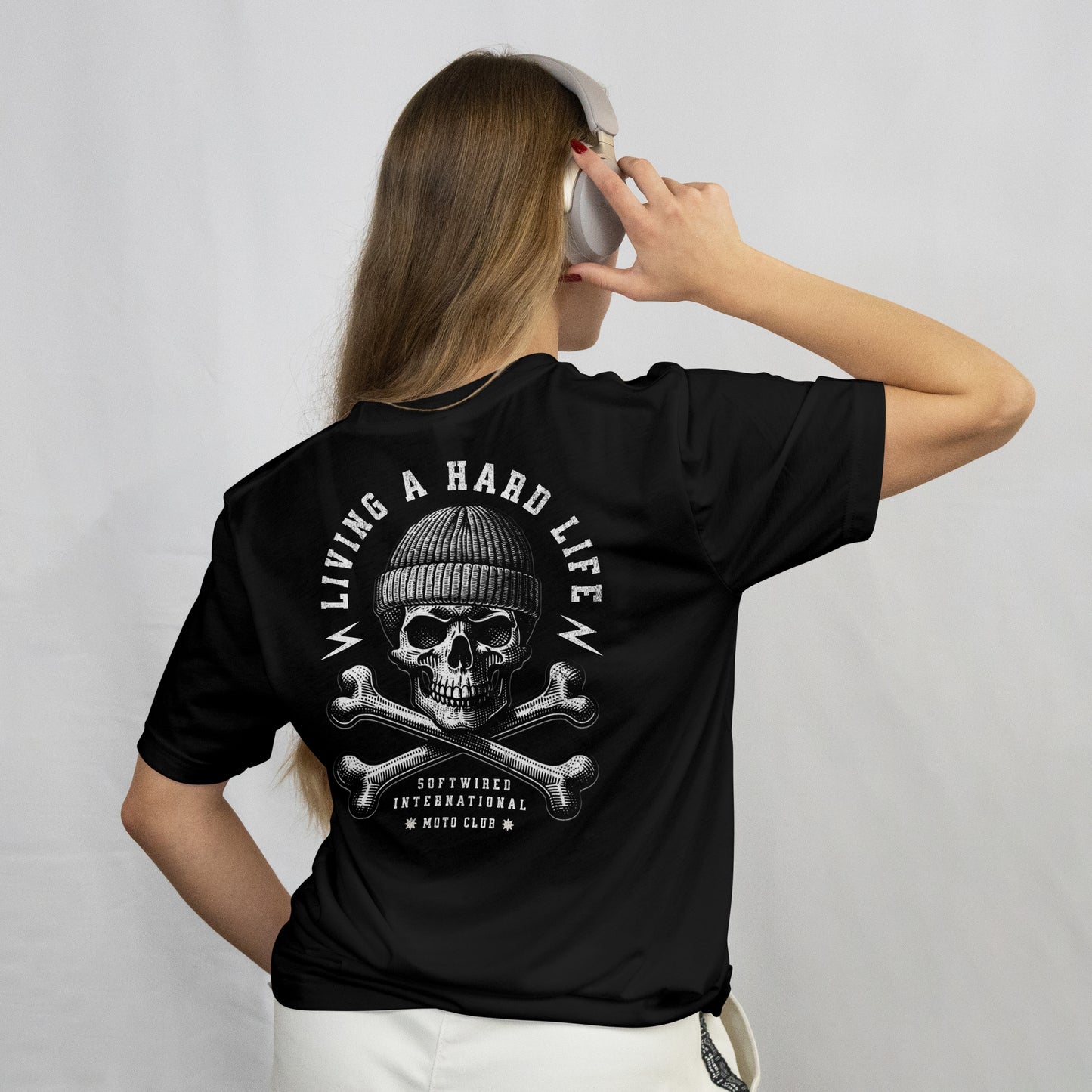 Person wearing a black t-shirt with a skull and crossbones design on the back, against a plain background.