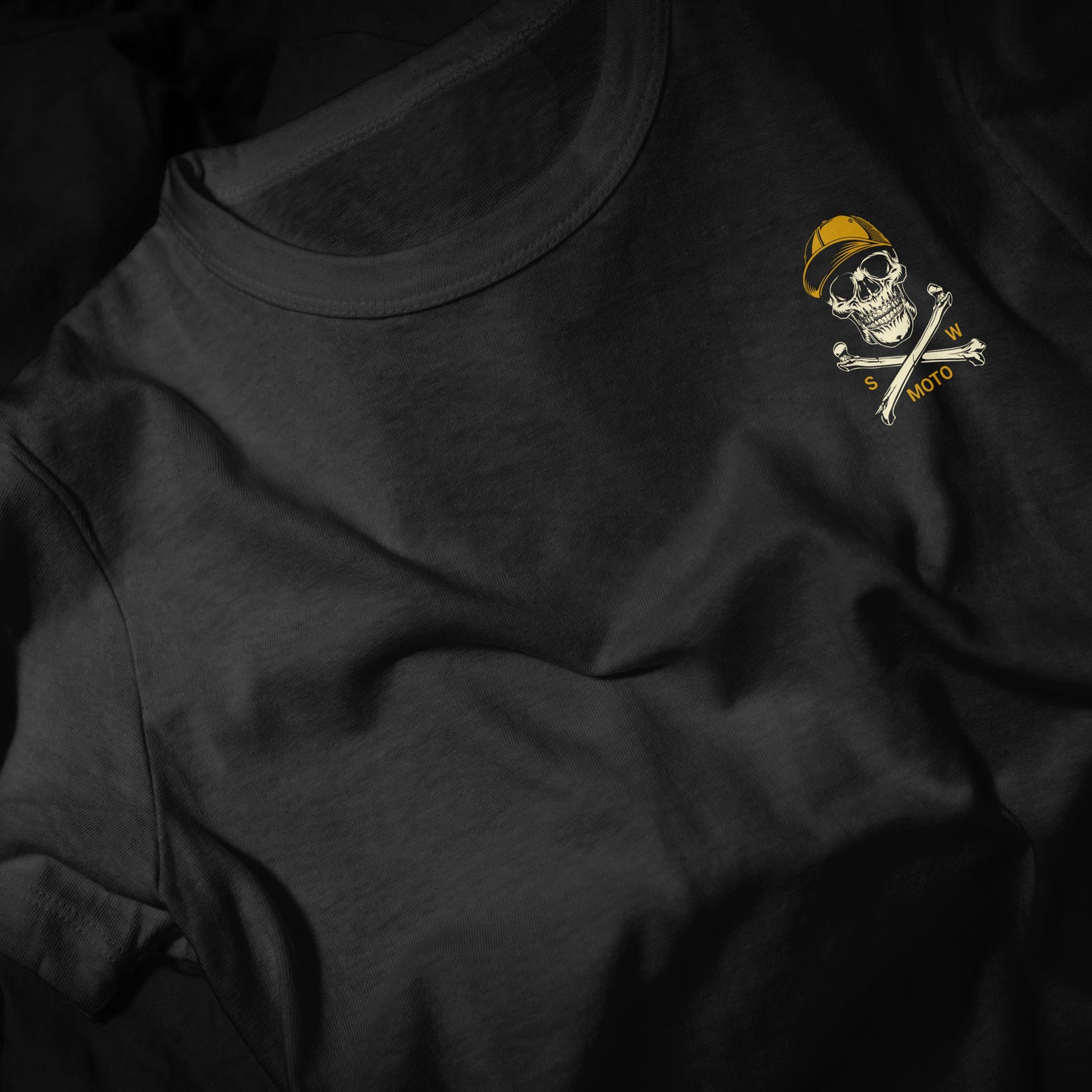 Black t-shirt with a skull and crossbones design on a dark background