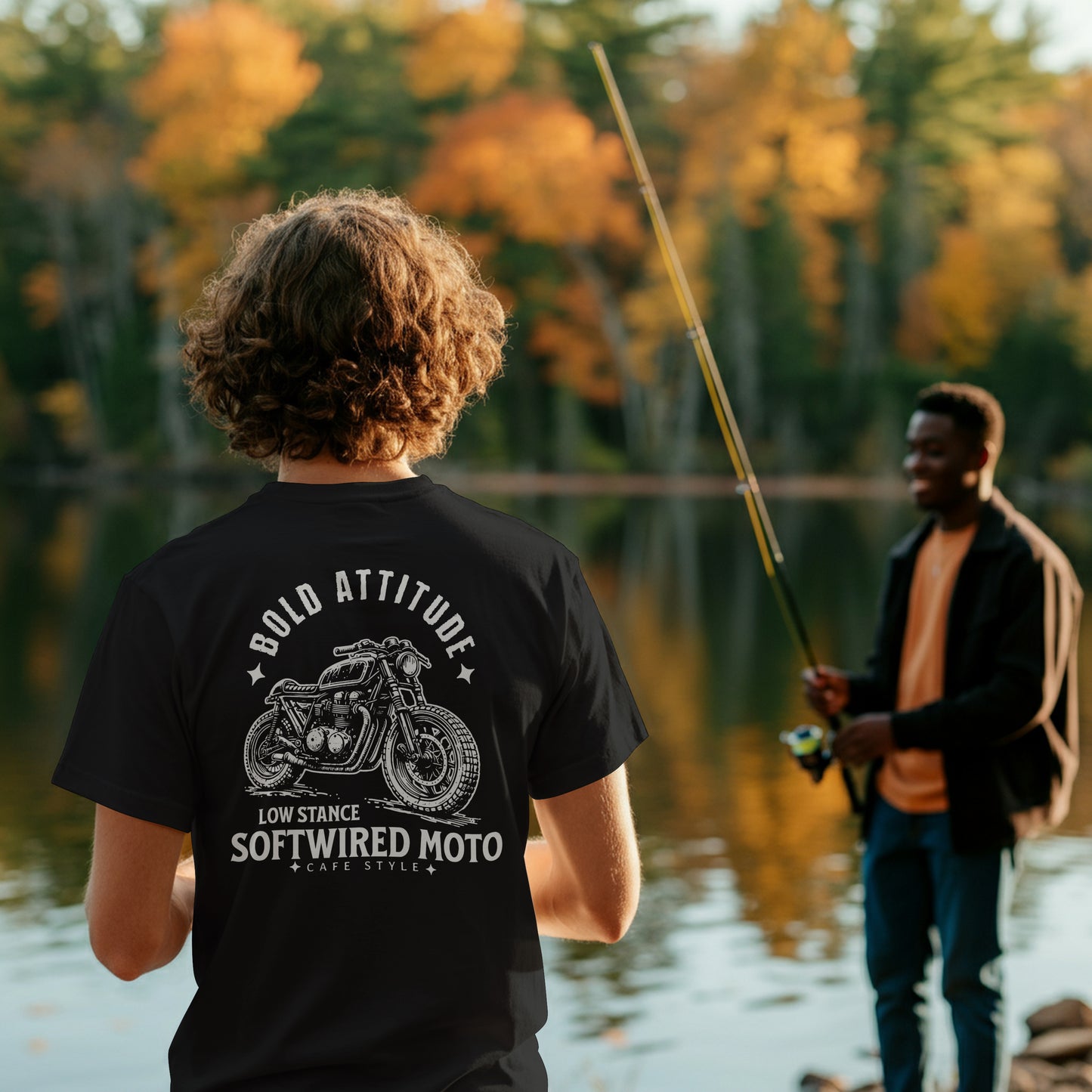 Two people by a lake with one wearing a black t-shirt with motorcycle graphic and text.