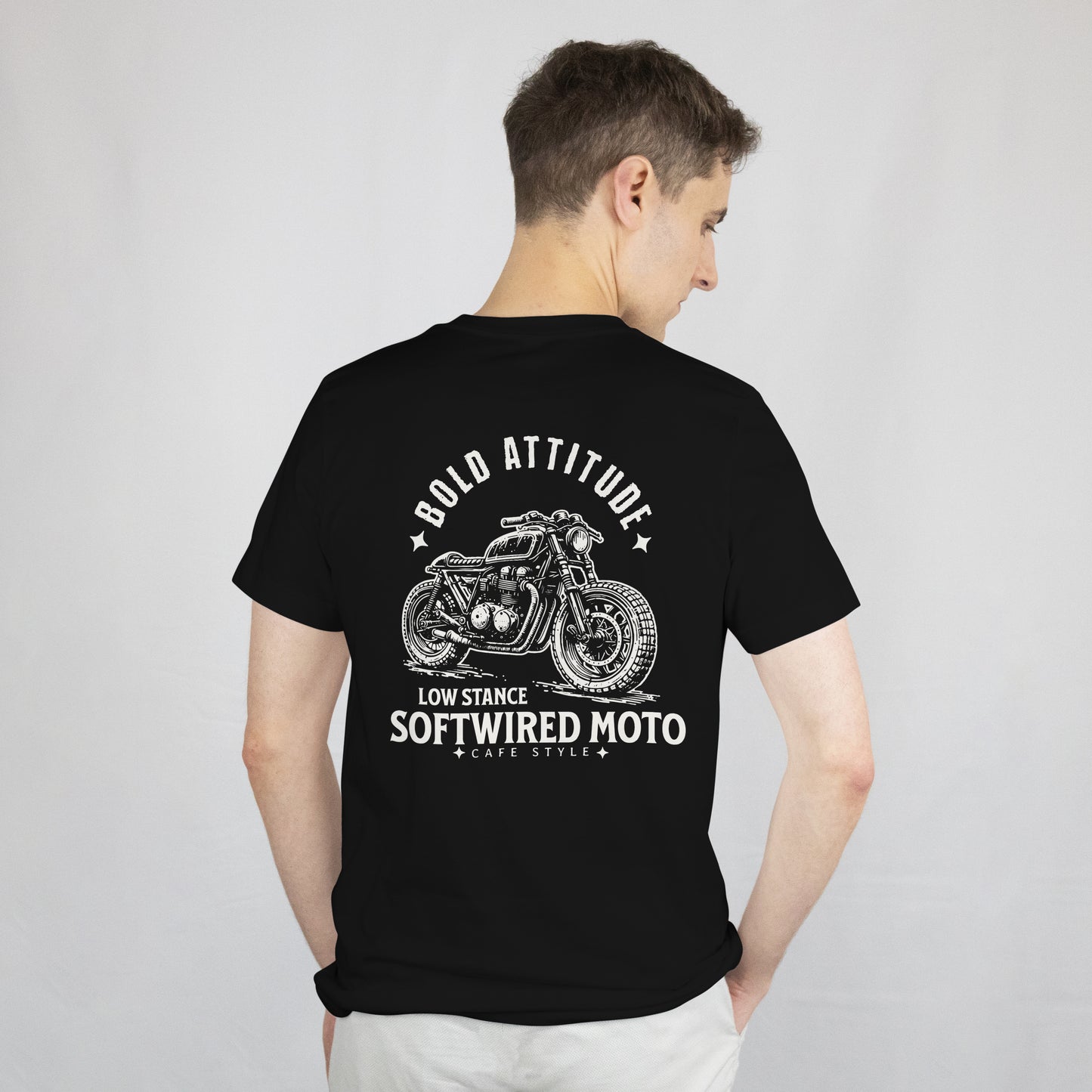 Person wearing a black t-shirt with a motorcycle graphic and text on the back against a plain background